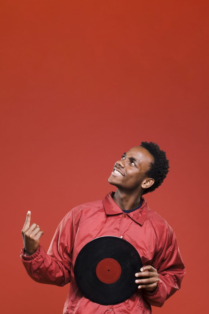 artist holding a vinyl and pointing up
